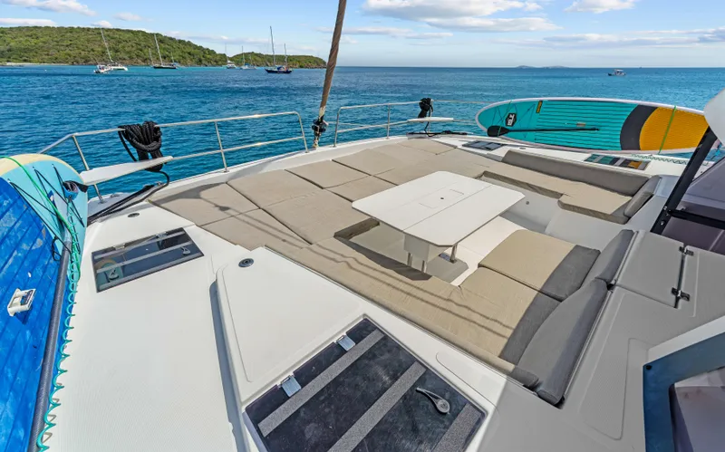 Always Sunday Yacht Photos Pics Luxurious Bali 4.8 catamaran deck with sun loungers and paddleboards, 2022 model, anchored in serene waters.