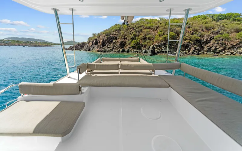Always Sunday Yacht Photos Pics Bali 4.8 yacht deck with seating, overlooking clear blue water and rocky shoreline, 2022 model.