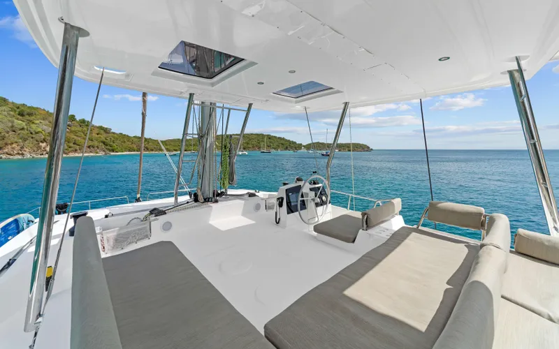 Always Sunday Yacht Photos Pics Luxurious 2022 Bali 4.8 catamaran with spacious deck, overlooking serene ocean and lush coastline.