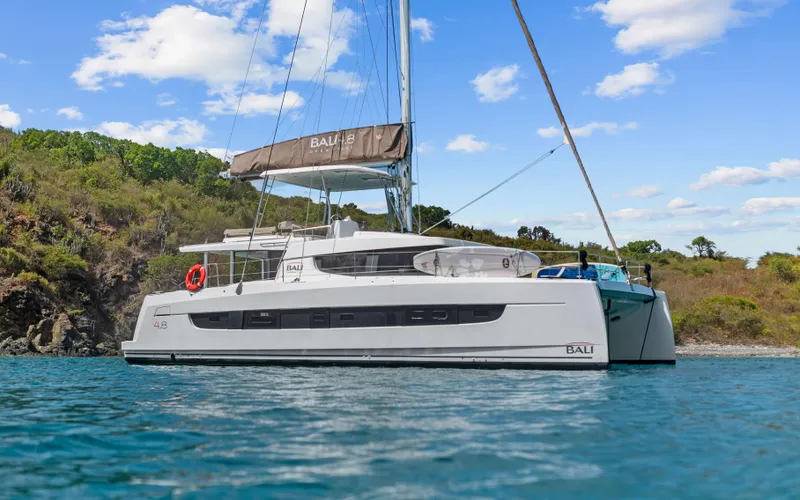 Always Sunday Yacht Photos Pics 2022 Bali 4.8 catamaran sailing near a scenic coastline under a clear blue sky.