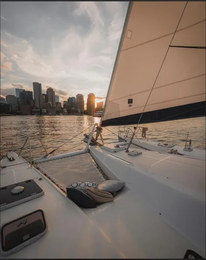 Blue Star Yacht Photos Pics Sailing yacht Privilege 43 at sunset with city skyline in the background.