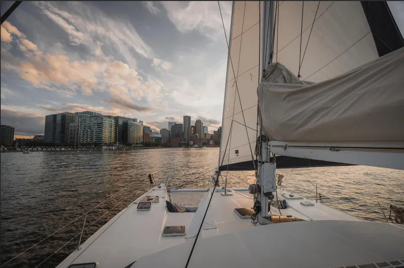 Blue Star Yacht Photos Pics Sailing yacht Privilege 43, 1993 model, approaching city skyline at sunset.