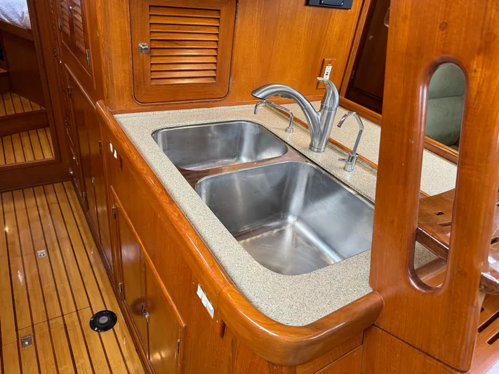 Shearwater Yacht Photos Pics Wooden yacht kitchen with dual sinks, Hylas 46, 2008 model, featuring elegant cabinetry.