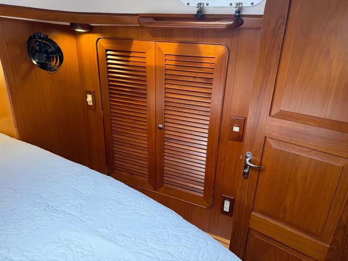 Shearwater Yacht Photos Pics Wood-paneled cabin interior of 2008 Hylas 46 yacht with louvered closet doors.