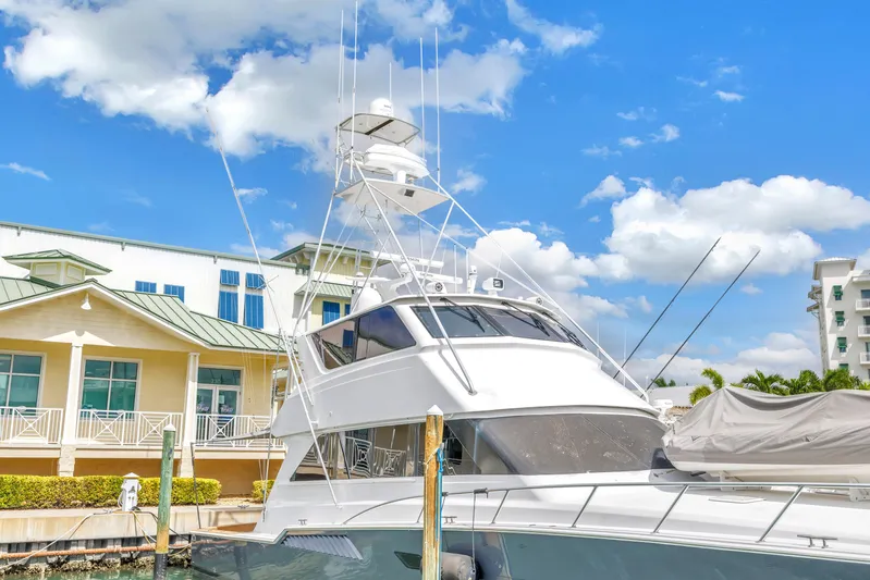 Reel Blonde Yacht Photos Pics 1999 Viking 72 Enclosed Bridge yacht docked under blue sky.