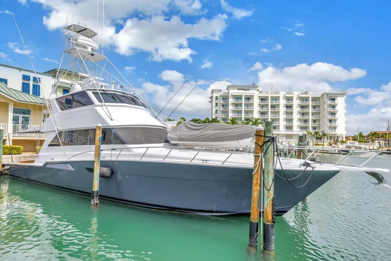 Reel Blonde Yacht Photos Pics 1999 Viking 72 Enclosed Bridge yacht docked in marina, clear sky, modern buildings.