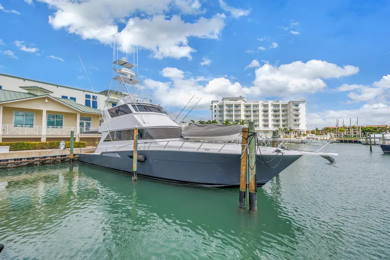 Reel Blonde Yacht Photos Pics 1999 Viking 72 Enclosed Bridge yacht docked in marina with buildings in background.