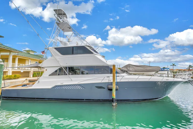 Reel Blonde Yacht Photos Pics 1999 Viking 72 Enclosed Bridge yacht docked in a marina under a blue sky.