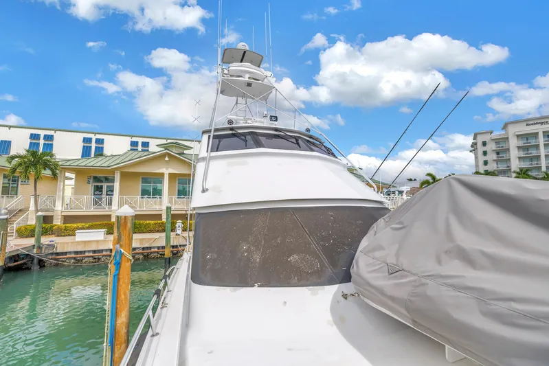 Reel Blonde Yacht Photos Pics 1999 Viking 72 Enclosed Bridge yacht docked at marina under blue sky.