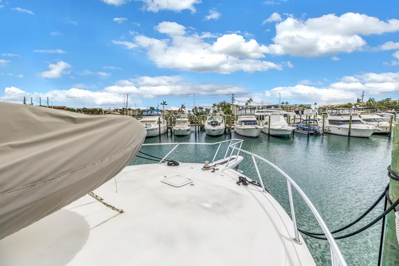 Reel Blonde Yacht Photos Pics 1999 Viking 72 Enclosed Bridge yacht docked in a marina under a bright blue sky.