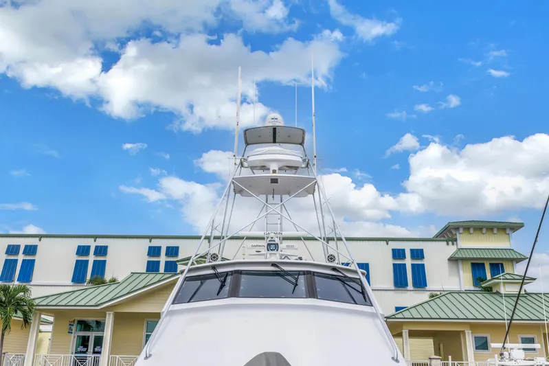 Reel Blonde Yacht Photos Pics 1999 Viking 72 Enclosed Bridge yacht against blue sky and building backdrop.