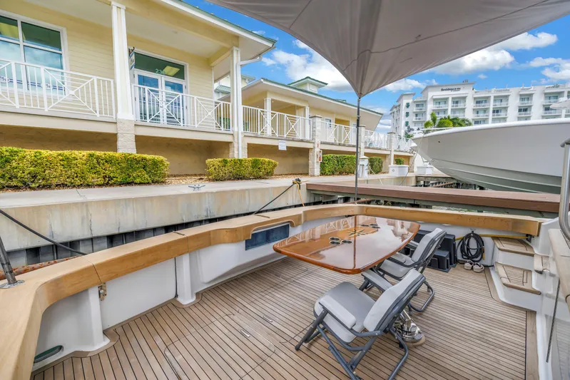 Reel Blonde Yacht Photos Pics 1999 Viking 72 Enclosed Bridge yacht docked, featuring a spacious deck with seating and table.