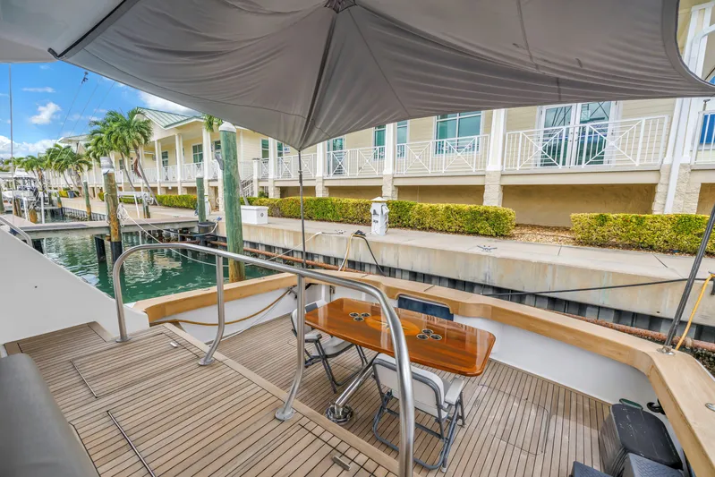 Reel Blonde Yacht Photos Pics 1999 Viking 72 Enclosed Bridge yacht docked, featuring a shaded deck with seating.