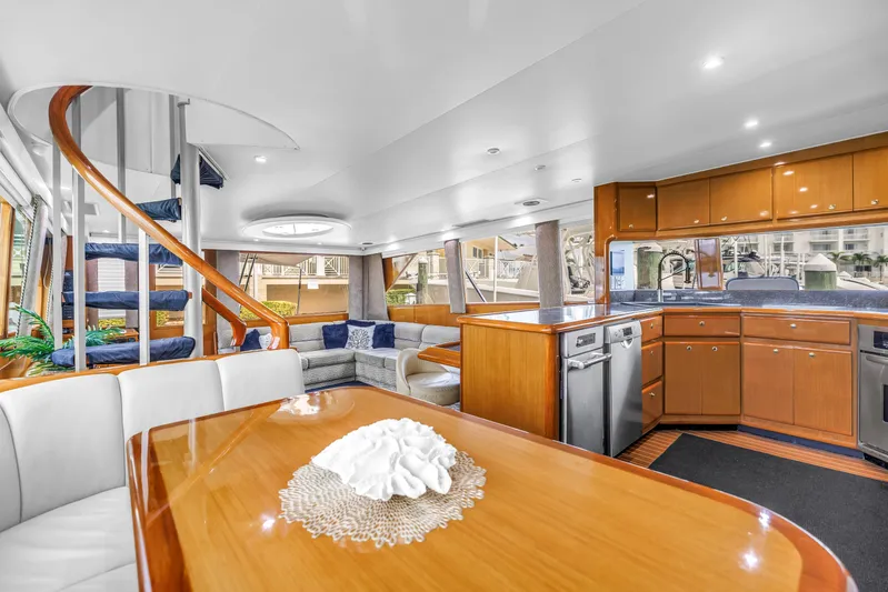 Reel Blonde Yacht Photos Pics Luxurious interior of 1999 Viking 72 Enclosed Bridge yacht with modern kitchen and spiral staircase.