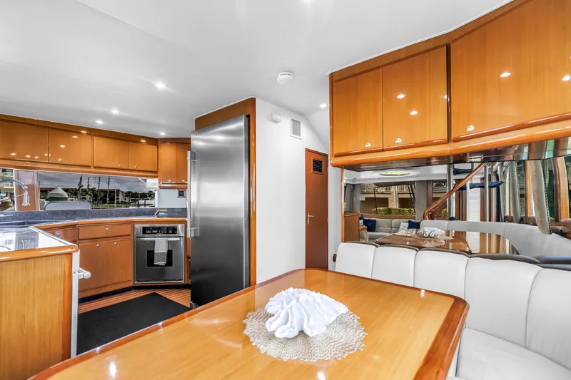 Reel Blonde Yacht Photos Pics Luxurious interior of 1999 Viking 72 Enclosed Bridge yacht with modern kitchen and dining area.