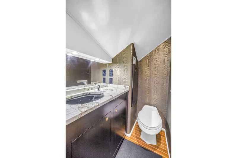 Reel Blonde Yacht Photos Pics Luxurious bathroom in 1999 Viking 72 Enclosed Bridge yacht with marble countertop and modern fixtures.