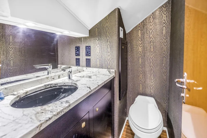 Reel Blonde Yacht Photos Pics Luxurious bathroom in 1999 Viking 72 Enclosed Bridge yacht with marble countertop and modern fixtures.