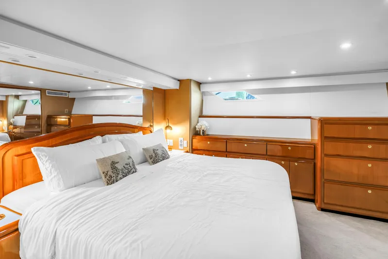 Reel Blonde Yacht Photos Pics Luxurious bedroom interior of 1999 Viking 72 Enclosed Bridge yacht with elegant wood furnishings.