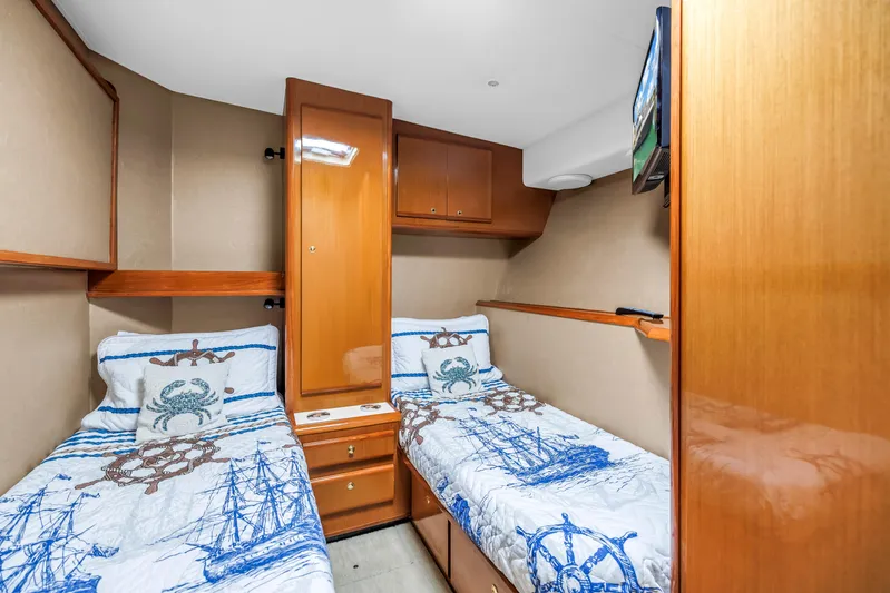 Reel Blonde Yacht Photos Pics 1999 Viking 72 Enclosed Bridge cabin with twin beds and nautical-themed bedding.
