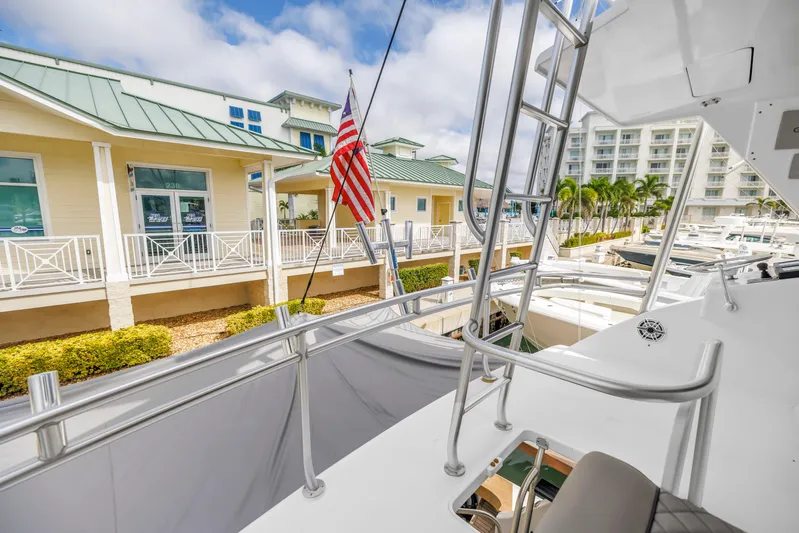 Reel Blonde Yacht Photos Pics 1999 Viking 72 Enclosed Bridge yacht docked at marina with American flag.
