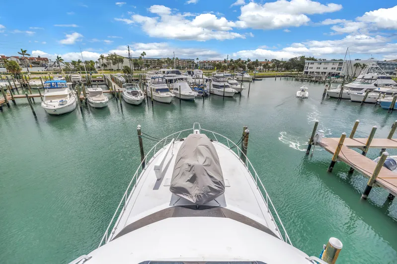 Reel Blonde Yacht Photos Pics 1999 Viking 72 Enclosed Bridge yacht docked in a marina under a bright blue sky.