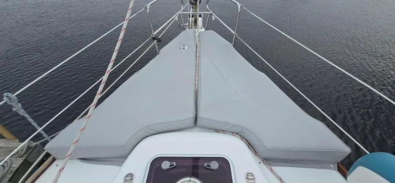 Diamant Noir Yacht Photos Pics Bow view of 2011 Beneteau Oceanis 46 sailboat with gray cushions and railing.