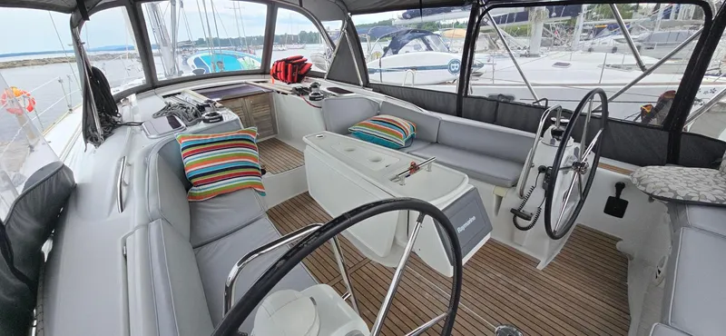 Diamant Noir Yacht Photos Pics Cockpit of 2011 Beneteau Oceanis 46 sailboat with striped cushions and dual steering wheels.