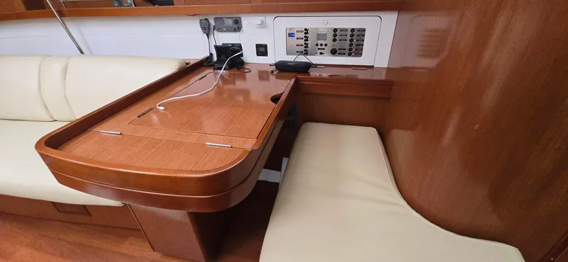 Diamant Noir Yacht Photos Pics Interior of 2011 Beneteau Oceanis 46 yacht with wooden table and beige seating.
