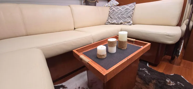 Diamant Noir Yacht Photos Pics Luxurious interior of 2011 Beneteau Oceanis 46 yacht with beige seating and decorative candles.