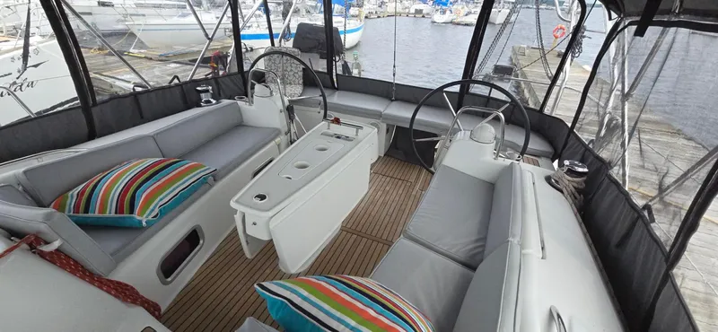 Diamant Noir Yacht Photos Pics 2011 Beneteau Oceanis 46 yacht cockpit with seating, striped cushions, and dual steering wheels.