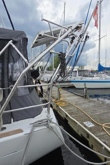 Diamant Noir Yacht Photos Pics Beneteau Oceanis 46 sailboat docked, showcasing stern and rigging, cloudy sky background.