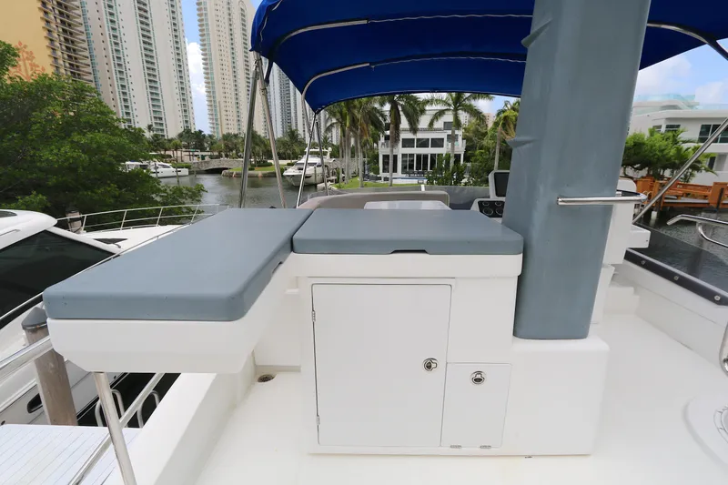  Yacht Photos Pics Azimut Magellano 43 yacht deck with blue canopy, 2014 model, docked near waterfront buildings.