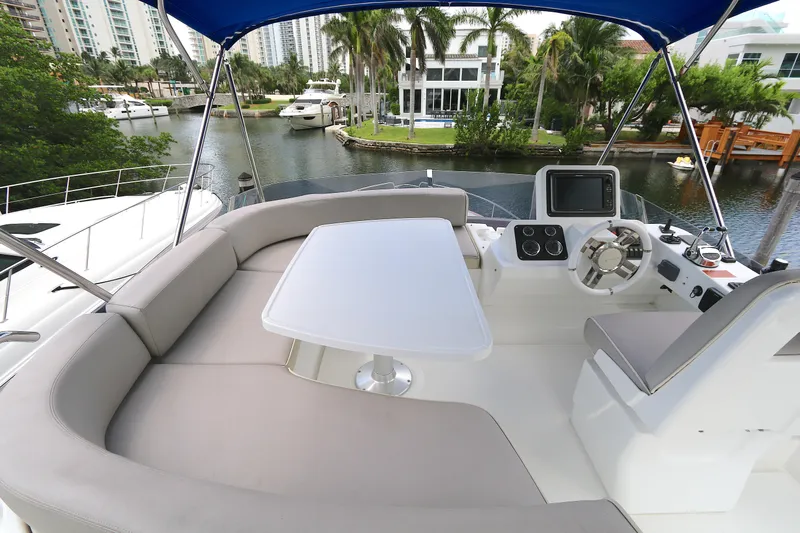  Yacht Photos Pics 2014 Azimut Magellano 43 yacht with spacious seating and helm, docked by waterfront homes.