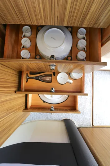  Yacht Photos Pics Azimut Magellano 43 yacht interior, 2014 model, featuring organized wooden drawers with dishes and cups.