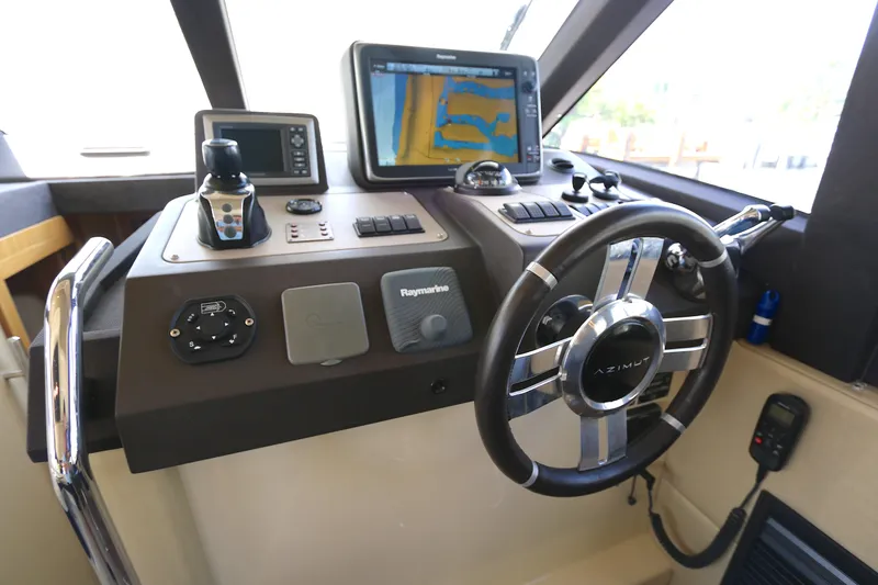  Yacht Photos Pics Control panel of 2014 Azimut Magellano 43 yacht with navigation equipment and steering wheel.