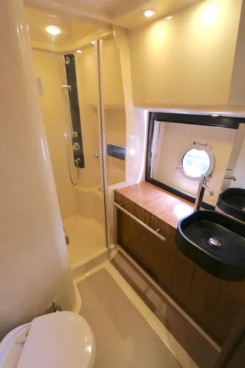  Yacht Photos Pics Luxurious bathroom in 2014 Azimut Magellano 43 yacht with modern fixtures and porthole window.