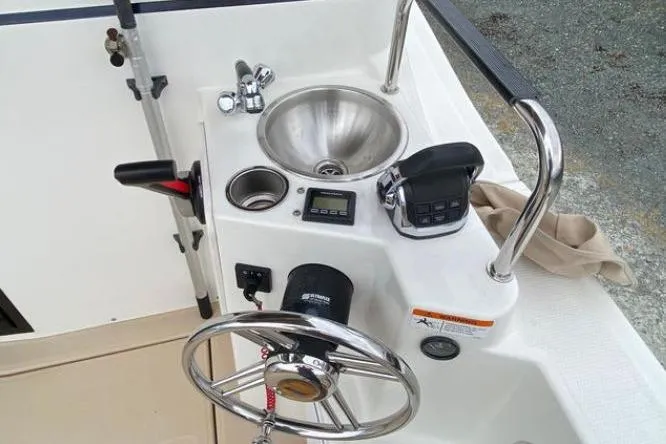 Lady K Yacht Photos Pics 2017 Cutwater C-28 boat helm with steering wheel, sink, and controls.