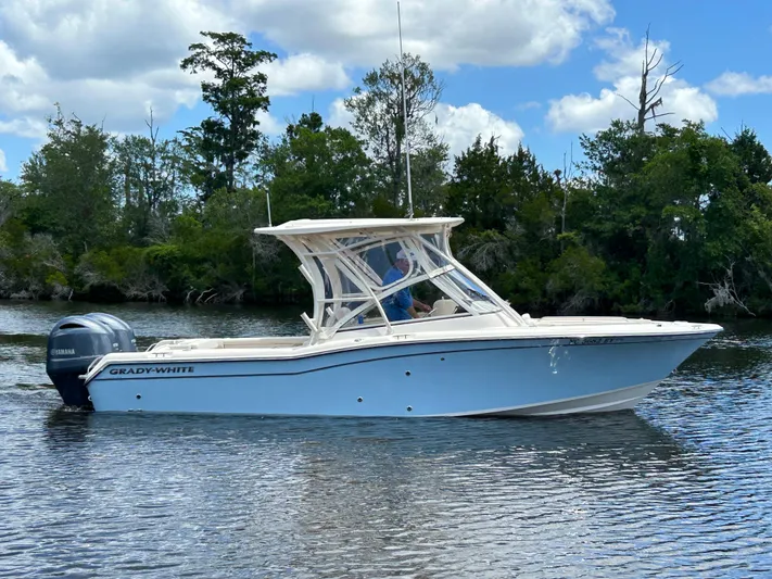  Yacht Photos Pics 2022 Grady-White 255 FREEDOM boat on calm water, surrounded by trees and blue sky.