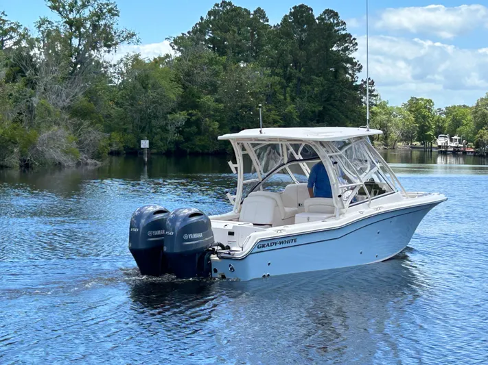  Yacht Photos Pics 2022 Grady-White 255 FREEDOM boat on a serene lake with lush green trees.