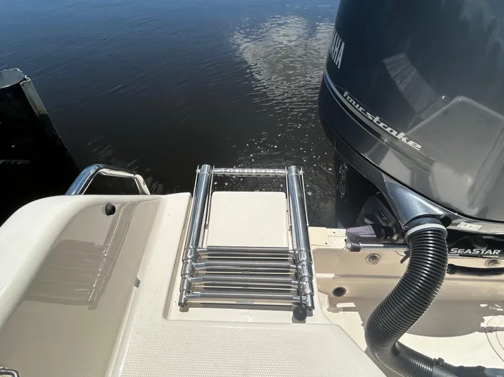  Yacht Photos Pics 2022 Grady-White 255 FREEDOM boat with ladder and outboard motor on calm water.