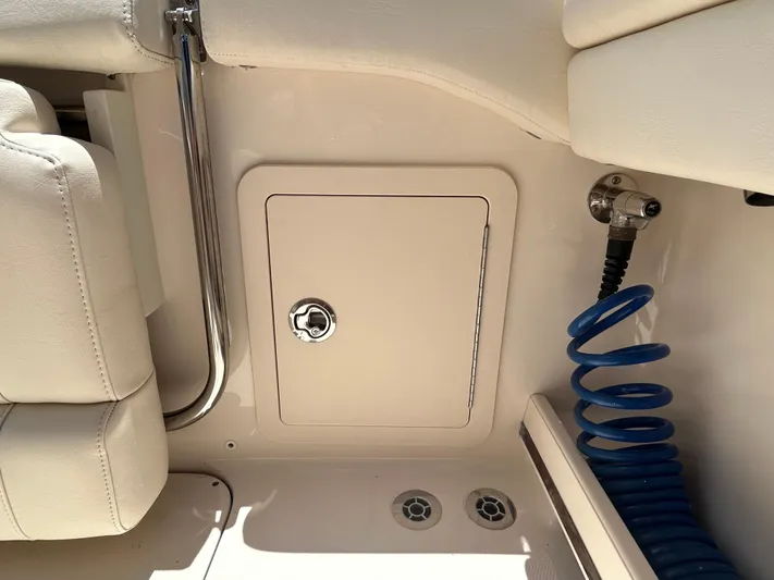  Yacht Photos Pics Interior view of 2022 Grady-White 255 FREEDOM boat, featuring storage compartment and coiled hose.