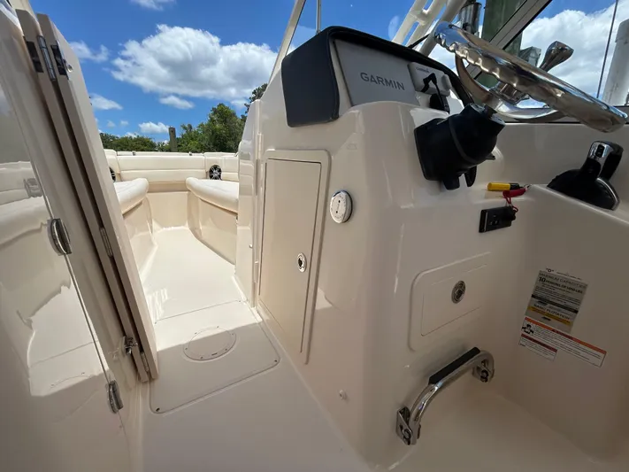  Yacht Photos Pics 2022 Grady-White 255 FREEDOM boat interior with steering console and seating, under blue sky.