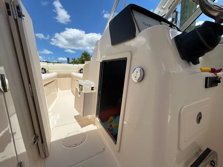  Yacht Photos Pics 2022 Grady-White 255 FREEDOM boat interior with open storage, under a clear blue sky.