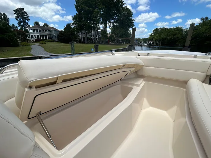  Yacht Photos Pics 2022 Grady-White 255 FREEDOM boat interior with open storage compartment, docked near waterfront homes.