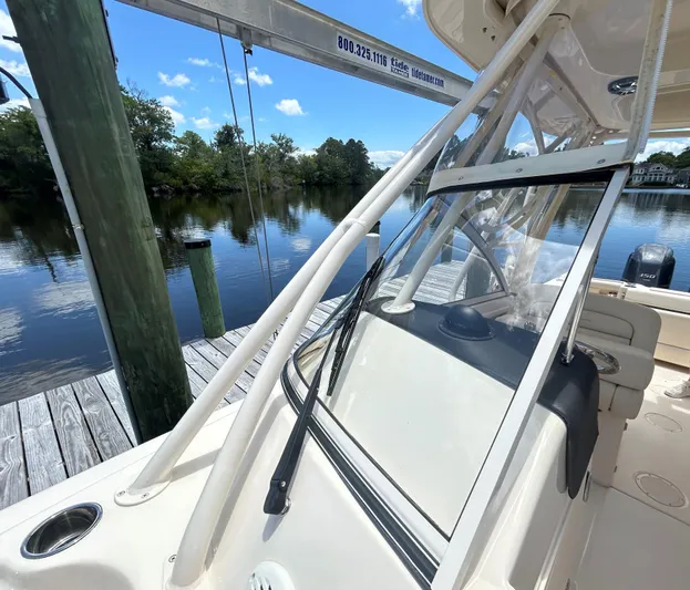  Yacht Photos Pics 2022 Grady-White 255 FREEDOM boat docked by a serene lake under a clear blue sky.