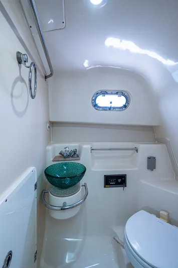  Yacht Photos Pics 2008 Pursuit OS 315 Offshore boat bathroom with modern fixtures and porthole window.