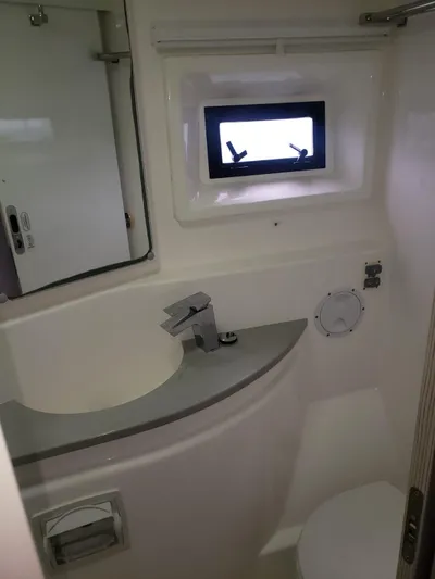 Miss Saigon Yacht Photos Pics Compact bathroom in a 2019 Leopard 51 Powercat with sink, faucet, and window.