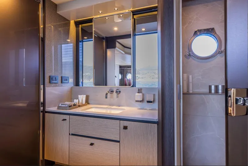 Absolute 56 Fly Yacht Photos Pics Luxurious bathroom interior of 2025 Absolute 56 FLY yacht with modern fixtures and porthole window.