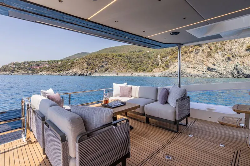 Absolute 56 Fly Yacht Photos Pics Luxurious Absolute 56 FLY yacht deck with elegant seating, overlooking serene coastal waters, 2025 model.