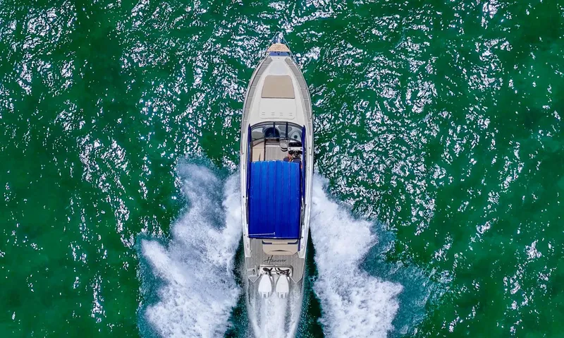 Custom Order Your 305 Today! Yacht Photos Pics Aerial view of 2025 Hanover 305 Outboard boat cruising on vibrant green water.